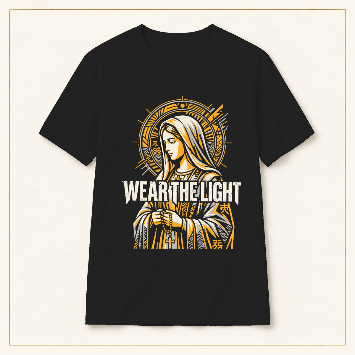 Marian Devotional T-Shirt — Wear the Light — black shirt on warm limestone with gold frame