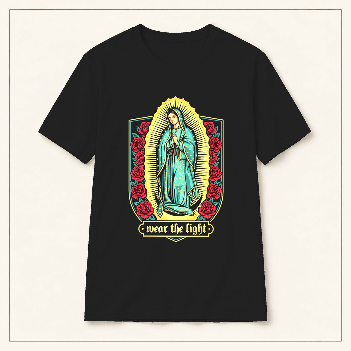 Our Lady of Guadalupe T-Shirt — Floral Devotional — black shirt on warm limestone with gold frame